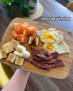 a person holding a cutting board with food on it and the words less brain fog