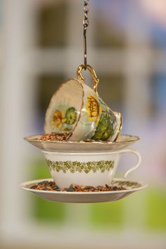 three teacups are stacked on top of each other and one is hanging from a chain