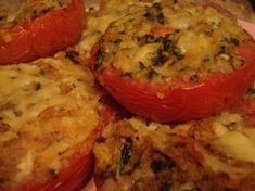 four stuffed tomatoes on a plate with cheese