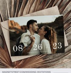 an image of a couple in love with the date printed on it, and palm leaves surrounding them