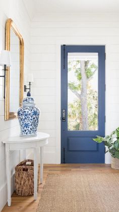 a blue and white vase sitting on top of a wooden floor next to a door