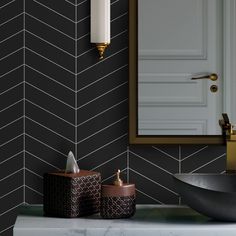 a bathroom with black and white herringbone tiles on the wall next to a sink