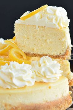 two slices of cheesecake with whipped cream and orange zest on top, sitting on a cooling rack