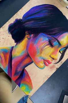 a woman's face is painted in rainbow colors