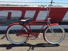 a red bicycle parked in front of a fence