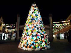 a brightly lit christmas tree in the middle of a shopping mall