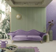 a purple couch sitting next to a table on top of a rug