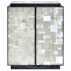 a white and black cabinet with many different tiles on it's doors, one door open to the other side