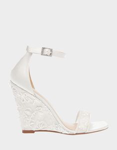 a white wedged sandal with an open toe and floral design on the heel