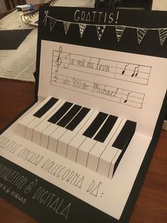 a piano made out of paper with notes and numbers on the front, sitting on top of a wooden table