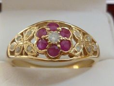 This Beautiful Vintage Inspired Ruby & Diamond Flower ring has been crafted from 9ct Solid Yellow Gold. A claw set GENUINE Natural Earth Mined Diamond and surrounding NATURAL Ruby petals with milgrain edging brings this ring to life. Resting on the shoulders of this splendid ring are exotic butterflies which have been inset with diamonds. THIS VINTAGE INSPIRED RUBY & DIAMOND FLOWER-BUTTERFLY RING IS TRULY AN EXQUISITE FINE JEWELLERY PIECE WHICH IS TO BE TREASURED FOR A LIFETIME ! ------- Gold Flower Ruby Ring, Gold Ruby Flower Ring For Anniversary, Exotic Butterflies, Diamond Butterfly Ring, Ruby Flower, Diamond Flower Ring, Diy Jewelry Rings, Gold Flower Ring, Diamond Butterfly