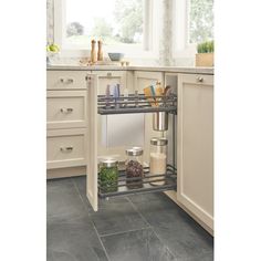 a kitchen with white cabinets and gray tile flooring, an open pull out shelf in the middle