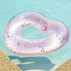 an inflatable swimming ring floating on top of a pool with sand around it