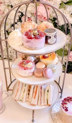 three tiered trays filled with different types of cakes and pastries on top of each other