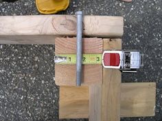 a piece of wood with a measuring tape on it next to a pair of construction tools