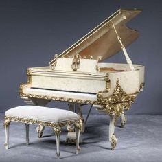 an ornately decorated grand piano and foot stool