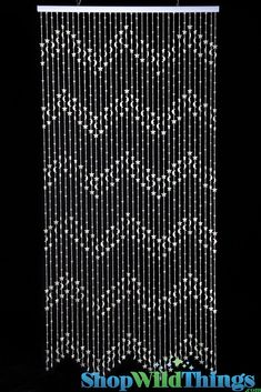 the beaded curtain is hanging in front of a black background with white beads on it