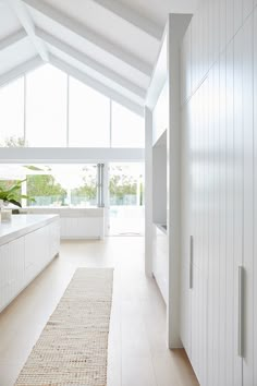 a kitchen with white cabinets and an area rug