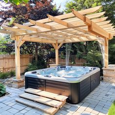 an outdoor hot tub in the middle of a patio with wooden pergolated structures