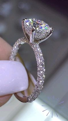 a close up of a person holding a diamond ring