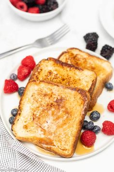 two pieces of french toast on a plate with berries