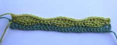 a green crocheted piece of yarn sitting on top of a table