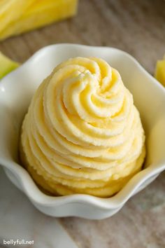 a close up of a bowl of food with bananas in the background