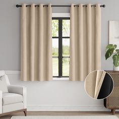 a living room with a white couch and beige curtains in front of a large window