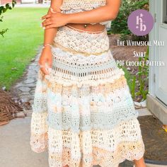 a woman standing in front of a house wearing a skirt and crop top with crochet