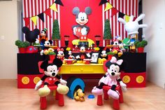 mickey mouse birthday party decorations and table with stuffed animals on the table, including minnie mouse