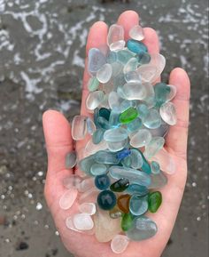 a person holding some glass pebbles in their hand