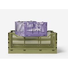 a purple crate sitting on top of a white floor next to a green box with the word joppe written on it