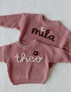 two pink sweaters with the word hello written on them