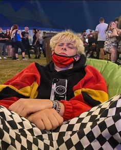 a person sitting in a chair with a camera on their face and covering his mouth