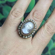 An absolutely stunning mid century cameo ring with a delicately carved cameo surrounded by a halo of genuine seed pearls, set high atop a lacy 18k yellow gold frame.  This lovely Victorian revival ring was a family heirloom that I am passing to a new owner! It was purchased for my grandmother in the late 1960s to early 1970s and has quite the story if you're interested- but I'm convinced it's very lucky! It does not have any hallmarks but has been tested as 18k gold. It measures a size 8 and total weight is 10.44 grams. It is in excellent condition and ready to be passed on for generations to come! This ring will ship Priority Mail with insurance included. Victorian Memorial Jewelry Ring, Antique Pearl Ring With Cabochon For Formal Occasions, Antique Pearl Ring With Cabochon For Formal Events, Antique 14k Stamped Pearl Ring Gift, Antique Oval Pearl Ring Stamped 14k, Victorian Cabochon Pearl Ring As Gift, Victorian Cabochon Pearl Ring Gift, Victorian Oval Cabochon Pearl Ring, Victorian Style Cabochon Pearl Ring Gift