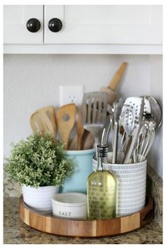 kitchen utensils and spoons are arranged in a tray on the counter top