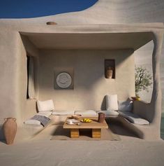 a living room filled with white furniture next to a wall covered in mud and sand