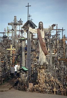 a statue of jesus surrounded by many crosses