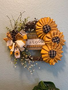 a wreath with flowers and ribbons hanging on the wall