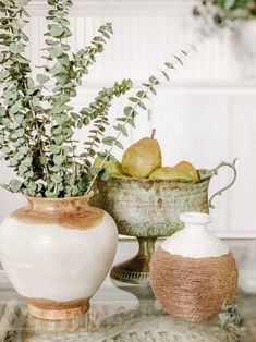 two vases filled with fruit sitting on top of a table next to each other