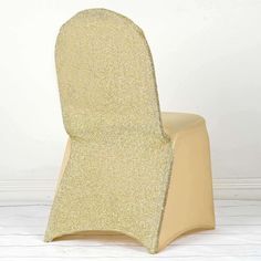 the back of a chair covered in gold glitter fabric, against a white wall and floor