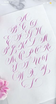 the letters and numbers are in cursive writing on paper with pink flowers next to it