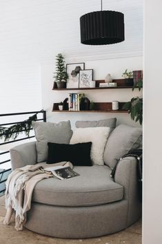 a living room with a round couch and bookshelf on top of the wall