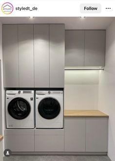 a washer and dryer in a room with white cabinets on either side of the washer and dryer