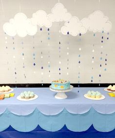 a blue table topped with cakes and cupcakes