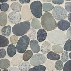 several different colored rocks are arranged on the wall in this mosaic tile pattern, which looks like it could be used as a floor covering