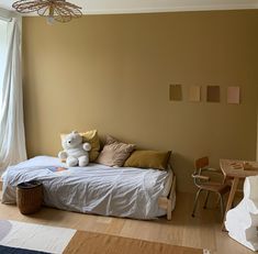 a bedroom with a bed, desk and chair in it's corner next to a window