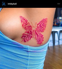 a woman's stomach with a pink butterfly tattoo on her back and the words ink by kai