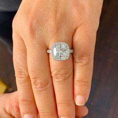 a woman's hand with a diamond ring on top of her finger and an engagement band