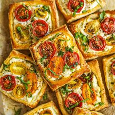 many square pieces of bread with tomatoes and cheese on them are arranged in a pattern